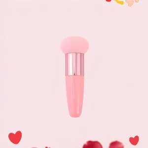 Detail of a pink sponge makeup brush with gold ferrule and streamlined handle