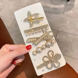 Detailed close-up of a 5-piece gold hair clip set with sparkling rhinestones and pearls