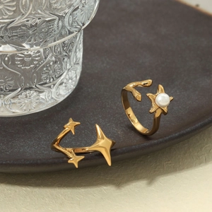 Golden starburst open rings with white pearl inlay on elegant ceramic plate