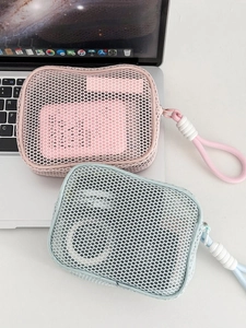 Detail view of mesh makeup pouches in pink and blue with pearl zipper on a laptop