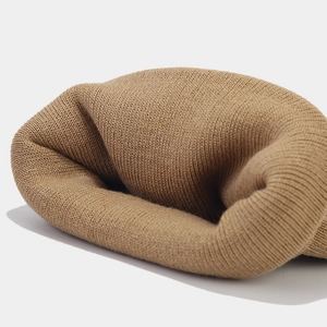 Close-up of camel knit beanie showing soft ribbed texture and premium woven fabric