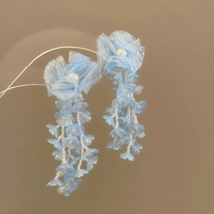 Detailed view of blue chiffon flower earrings with white pearls and delicate floral tassels