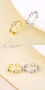 Macro detail of gold and silver plated H-link twist rings with sparkling pavé zircons