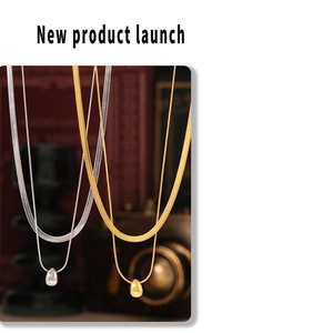 Detail of layered gold and silver snake chains with polished water drop pendants