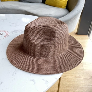Detailed cross-weave texture of a brown straw fedora hat for summer sun protection