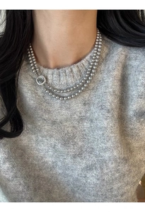 Detail of double-layer grey pearl necklace featuring a square shell-inlaid clasp