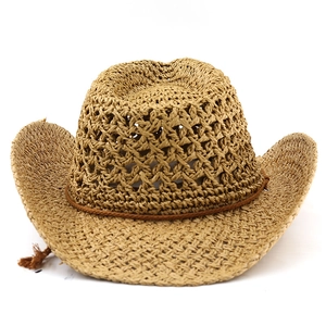 Detailed macro of vintage western straw hat featuring hollow-out weave and brown cord