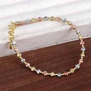 Close-up of tricolor metal beaded bracelet in gold silver and rose gold with faceted beads