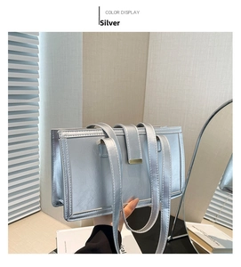 Close-up of metallic silver box bag with gold trim and dual shoulder straps