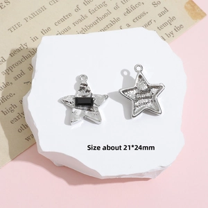 Macro shot of silver Y2K star pendant with black resin inlay and size measurement detail