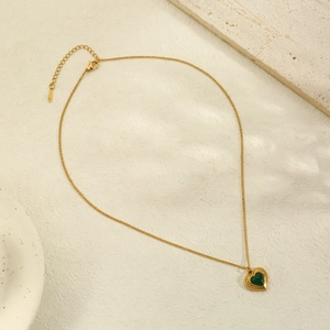 Close-up of heart necklace with green stone, gold finish and lobster clasp detail