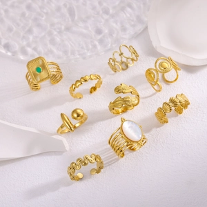 Set of 9 gold adjustable rings featuring heart leaf and shell designs on a white stone