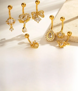 Detailed view of bohemian navel rings with cubic zirconia charms on golden titanium steel