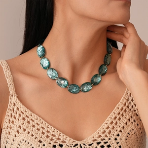 Vintage teal resin oval bead necklace with gold rings on a female model neck