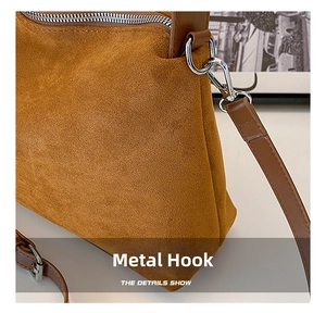 Detail of silver metal hardware and smooth brown suede texture on a vintage tote bag