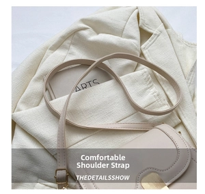 Detail of beige leather crossbody bag with golden metal turn-lock on linen blazer