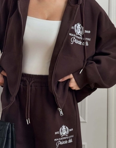 Détails du survêtement marron foncé avec broderie blanche sur le sweat et le pantalon