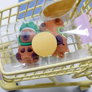 Macro view of natural kraft paper round labels on plastic figures in a mini shopping cart