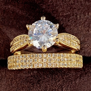 Luxe goudvergulde trouwringenset met ronde solitaire diamant en een pavé ring