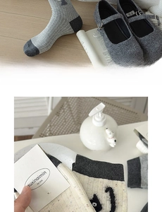 Close-up of soft cotton socks with embroidered smiley face and gray striped texture