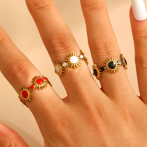 Three-piece gold sunflower ring set with red white and black enamel on model hand