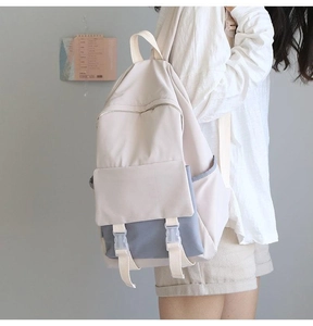Detail of minimalist dual-tone backpack in beige and light blue with buckle pocket