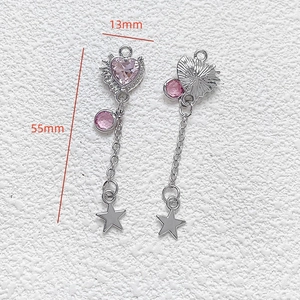 Detail shot of heart pendant charm with pink crystal and star tassel for DIY jewelry