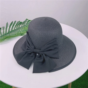 Détail d'un chapeau de paille tissé avec un grand nœud papillon noir élégant