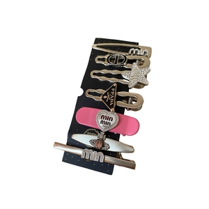 Set of 7 silver Y2K star and heart hair clips with rhinestone accents on a black card