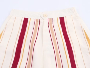 Détail du pantalon rayé en tissu tissé haute densité avec taille lisse et bouton rond