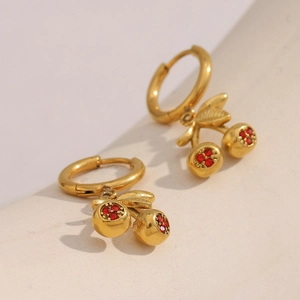Macro shot of 18K gold plated cherry earrings featuring vibrant red crystal accents