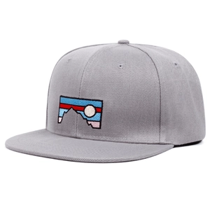 Detail of grey snapback cap featuring mountain embroidery patch and cotton twill texture