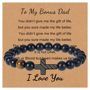 Detail of matte black beads with tiger eye stone and cross on a gift card for dad