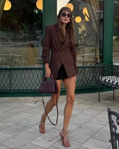 Vue de rue à la mode d'une femme portant un blazer oversize croisé marron foncé chic