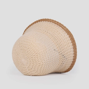 Detail of breathable beige knitted sun hat featuring elegant brown crochet trim edges