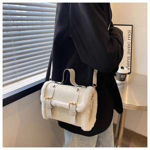 Detail of off-white plush crossbody bag with decorative buckles and top handle