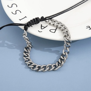 Silver stainless steel Cuban chain woven bracelet on a white plate with blue background