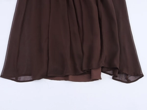 Detailed close-up of dark brown pleated chiffon hem with elegant sequin ribbon trim