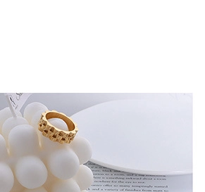 Macro detail of golden irregular wave ring with geometric texture on decorative prop
