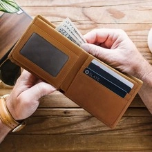 Macro detail of the interior of a brown leather waist bag with ID window and card slots