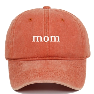 Close-up of white mom embroidery on washed orange cotton baseball cap with stitch detail