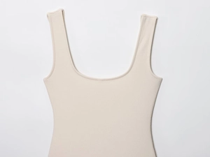 Detail of beige ribbed knit texture and scoop neckline on sleeveless bodysuit for women