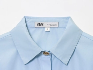 Detail of light blue shirt neckline showing the brand label and EUR S size tag