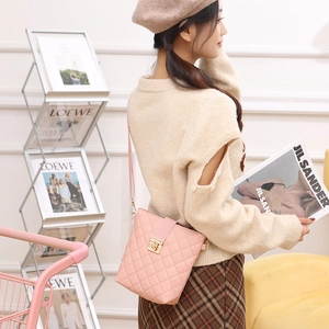 Pink quilted crossbody bag with gold buckle on model, elegant faux leather fashion handbag