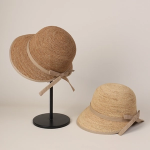 Elegant Raffia straw cloche hats with ribbon bows in dark brown and light beige colors
