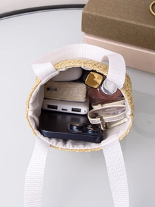Top view of large straw tote bag showing internal storage for phone and cosmetics