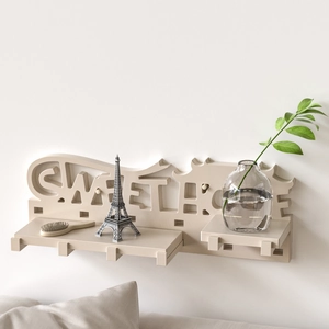 Detail of Sweet Home wall shelf with hooks and decorative cutout on a white wall