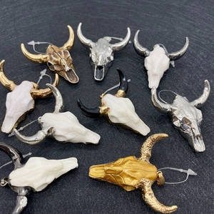 Macro view of bull skull charms in assorted gold, silver and white resin finishes