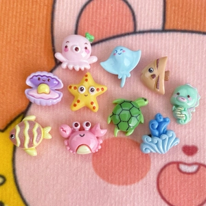 Flat lay of cute mini resin ocean animal charms like octopus and starfish for DIY crafts