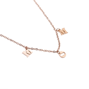 Rose gold stainless steel MOM necklace featuring three separate letter pendants on white background